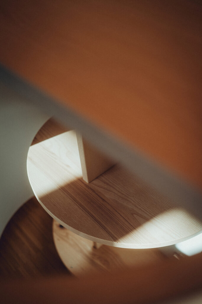 Eck-Einbauschrank nach Maß aus Esche und Linoleum mit warmer LED-Innenbeleuchtung.