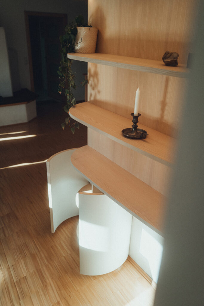 Eck-Einbauschrank nach Maß aus Esche und Linoleum mit warmer LED-Innenbeleuchtung.