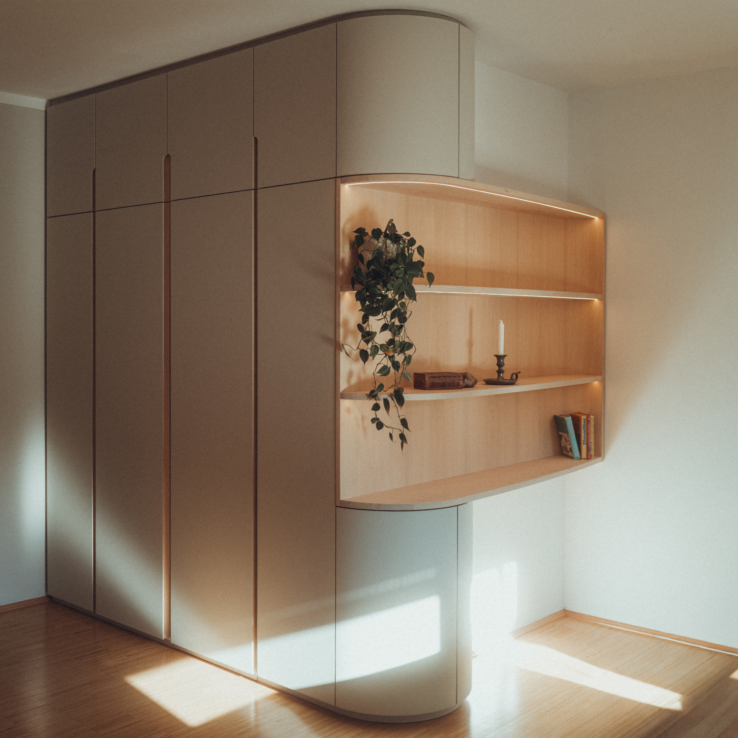 Eck-Einbauschrank nach Maß aus Esche und Linoleum mit warmer LED-Innenbeleuchtung.