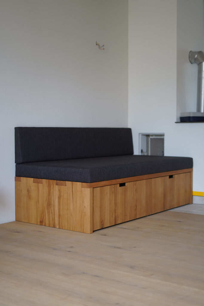 Schwebende Ecksitzbank aus massiver Eiche mit grauer Polsterung und passendem Esstisch für acht Personen.