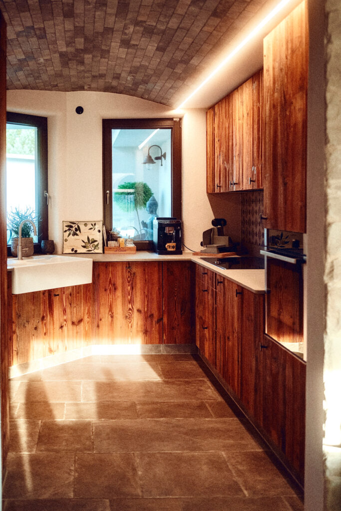 Individuelle Altholzküche mit Rohstahl-Elementen und maßgefertigtem Gewürzregal.