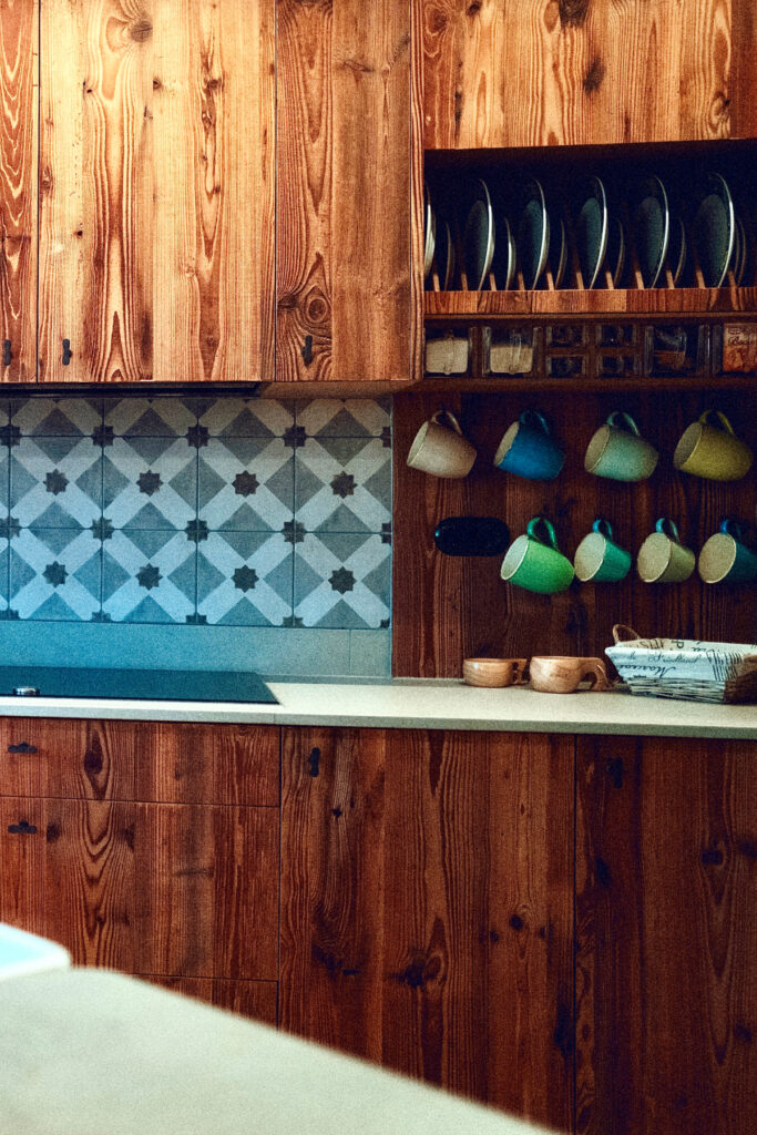 Individuelle Altholzküche mit Rohstahl-Elementen und maßgefertigtem Gewürzregal.