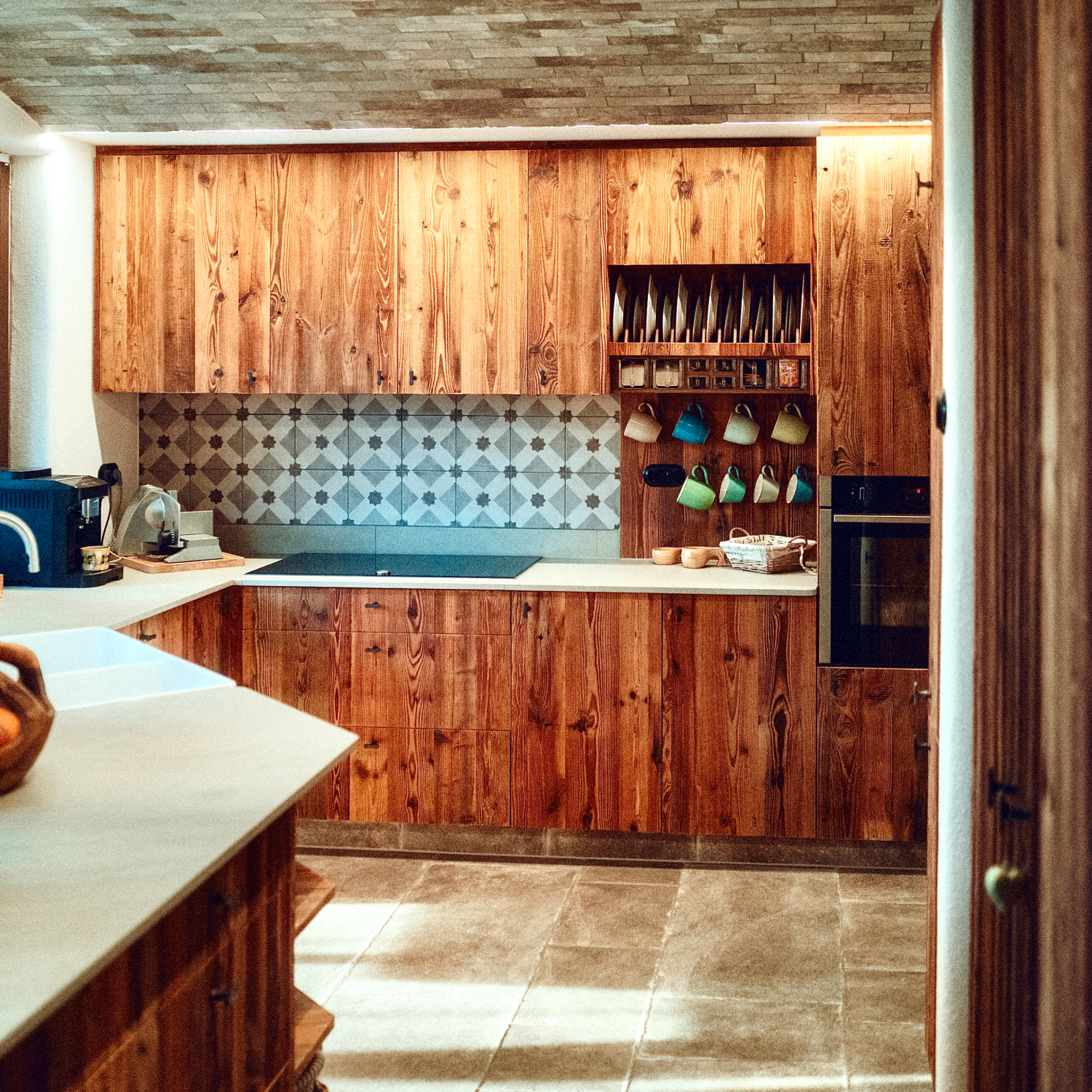 Individuelle Altholzküche mit Rohstahl-Elementen und maßgefertigtem Gewürzregal.