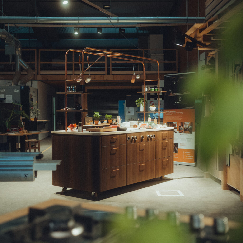 Mobile Showküche aus Räuchereiche mit Messing-Stellage und einer Arbeitsplatte aus Jura Kalkstein.