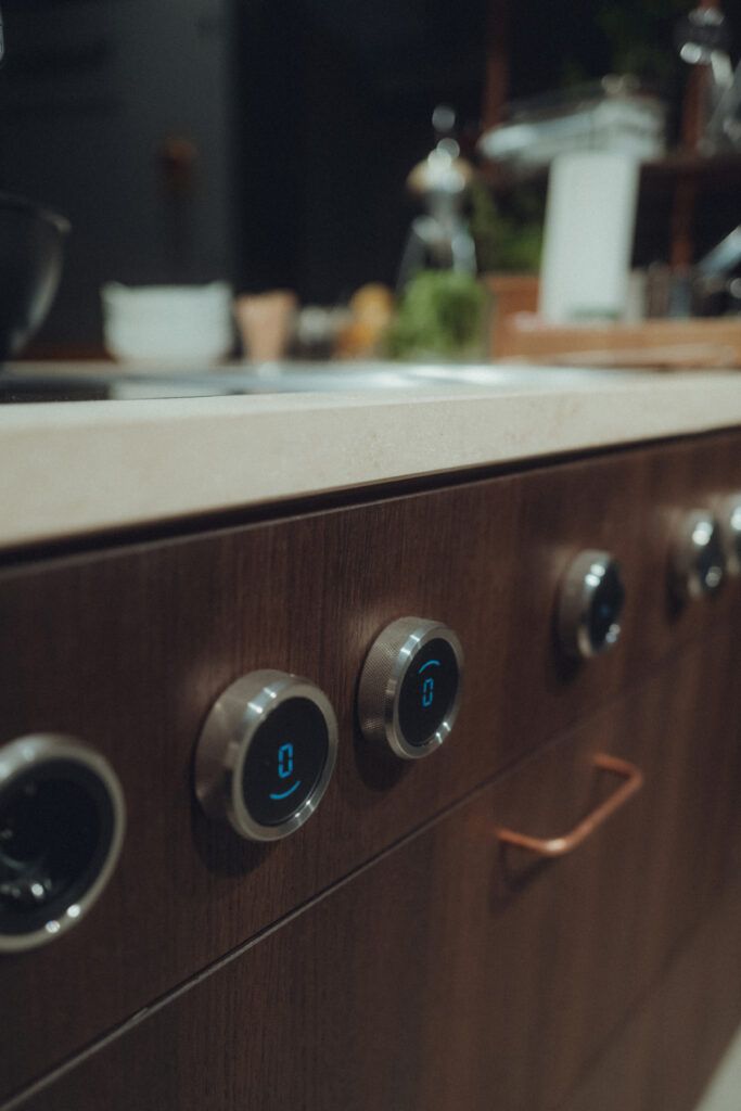 Mobile Showküche aus Räuchereiche mit Messing-Stellage und einer Arbeitsplatte aus Jura Kalkstein.