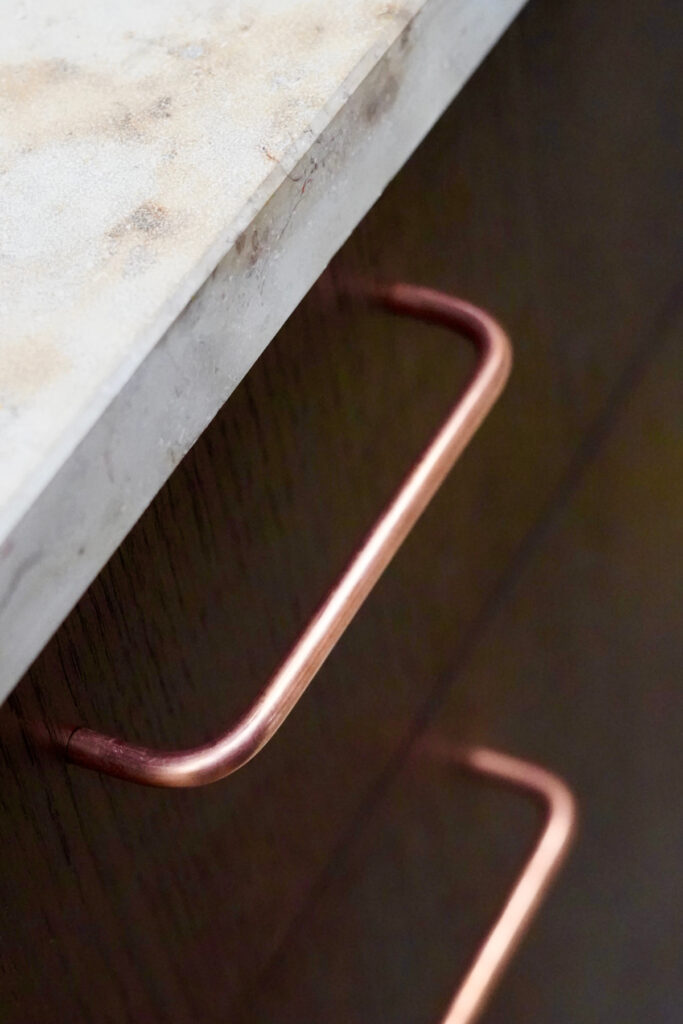 Mobile Showküche aus Räuchereiche mit Messing-Stellage und einer Arbeitsplatte aus Jura Kalkstein.