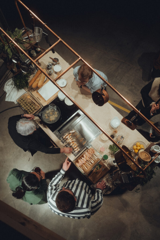 Mobile Showküche aus Räuchereiche mit Messing-Stellage und einer Arbeitsplatte aus Jura Kalkstein.