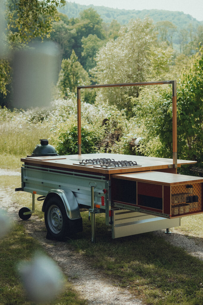 Mobile Outdoorküche moukit Modell 01 mit Gasherd, Spüle und Kühlung in der freien Natur.