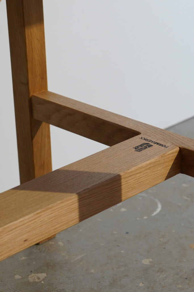 Esstisch Essenz aus massiver Eiche mit einer Tischplatte aus Fischgrät-Parkett und filigranen Beinen.