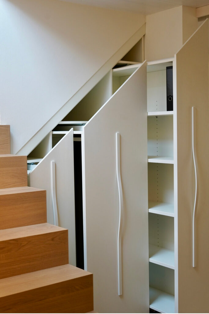 Einbau-Treppenschrank aus Eiche mit indirektem Lichtband am Handlauf.