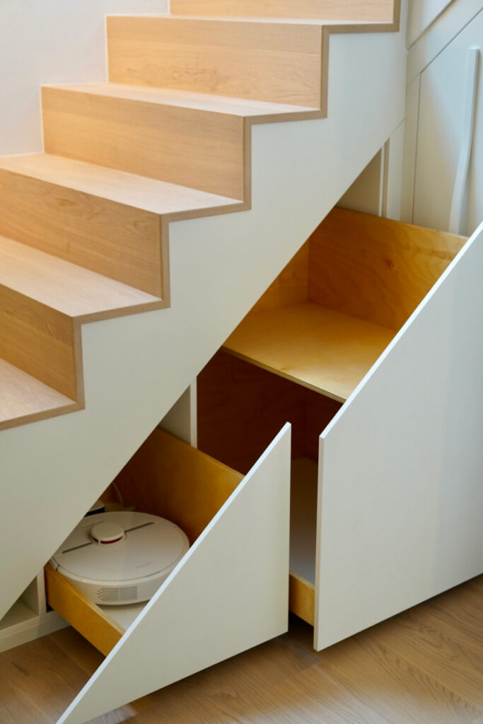 Einbau-Treppenschrank aus Eiche mit indirektem Lichtband am Handlauf.