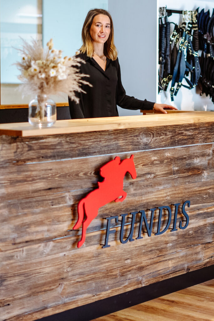 Exklusive Ladeneinrichtung aus Altholz, Eiche und Stahl für einen Reitsport-Shop mit Blick in die Reithalle.