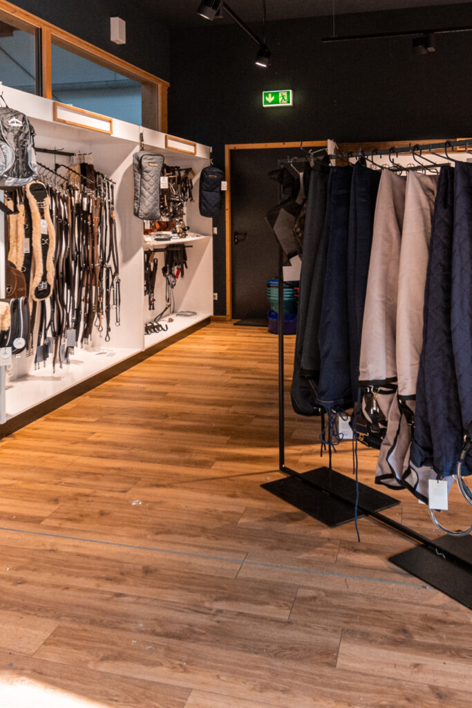 Exklusive Ladeneinrichtung aus Altholz, Eiche und Stahl für einen Reitsport-Shop mit Blick in die Reithalle.