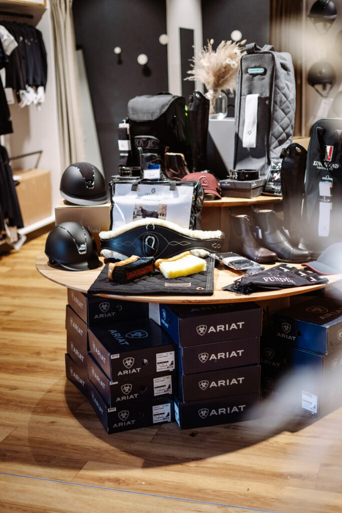 Exklusive Ladeneinrichtung aus Altholz, Eiche und Stahl für einen Reitsport-Shop mit Blick in die Reithalle.